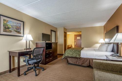 a hotel room with a bed and a desk with a computer at Quality Inn Tully I-81 in Tully
