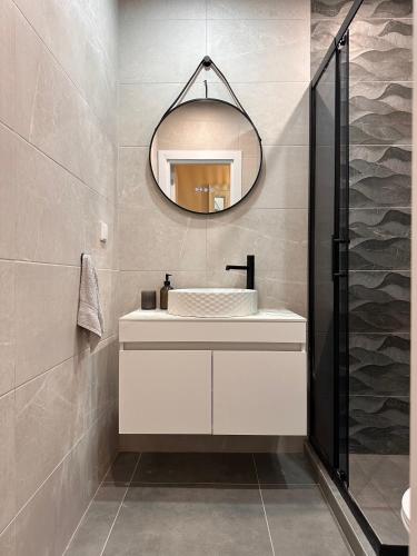 un bagno con un lavandino bianco e uno specchio di WaveApartment a Varna