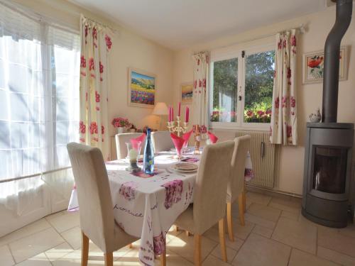una sala da pranzo con tavolo, sedie e camino di Villa in Garéoult with Private Pool a La Roquebrussanne
