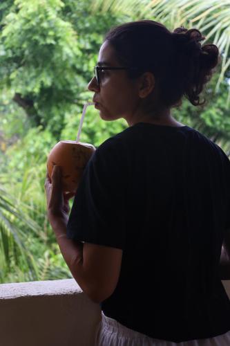a woman is drinking a drink with a straw at Wake N Flow, Ahangama - Kabalana Beach in Ahangama