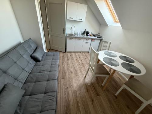 a kitchen and a living room with a table and a couch at Samaria Apartments in Šamorín