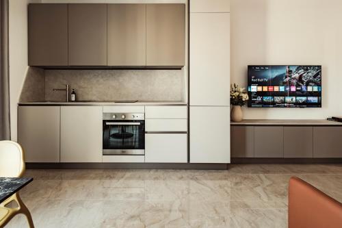 a kitchen with white cabinets and a stove at Mozart's Melody in Tal-Ħriereb