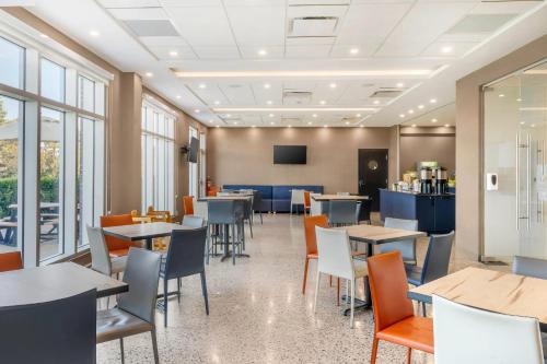 モン・ジョリにあるQuality Inn & Suitesのテーブルと椅子と窓のあるダイニングルーム