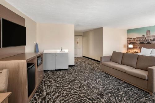 a living room with a couch and a flat screen tv at Clarion Pointe Indianapolis Airport in Plainfield