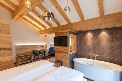 a bedroom with a bed and a bath tub at Hotel Alpi in Campitello di Fassa