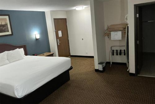a bedroom with a large white bed in a hotel room at Tombstone Grand Hotel, a Baymont by Wyndham in Tombstone