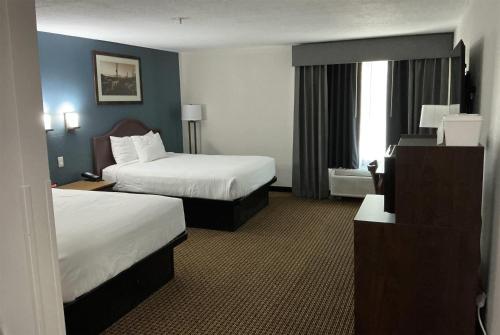 a hotel room with two beds and a window at Tombstone Grand Hotel, a Baymont by Wyndham in Tombstone