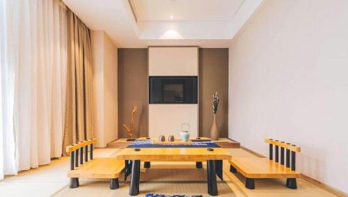 a dining room with a table and two benches at Atour Hotel Weihai Shidao in Dongshan