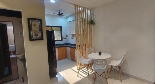 a dining room with a white table and chairs at Horizon Grande Apartments - Tarkarli in Malvan