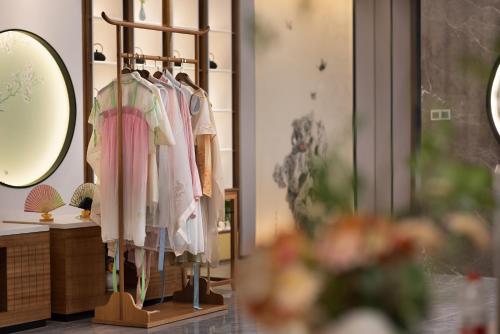 a dressing room with a rack of clothes at hanghzou moshangqingya hotel in Libu