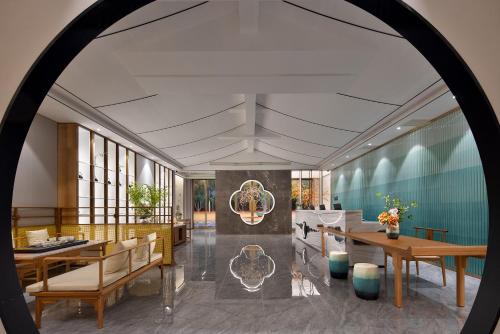 a rendering of a lobby with tables and chairs at hanghzou moshangqingya hotel in Libu