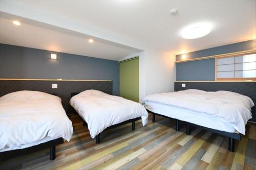 two beds in a room with green and blue walls at BU1 瀬々串 海テラスSesekushi Umi terrace in Kagoshima