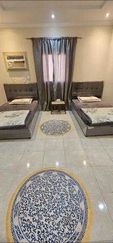 two beds in a room with two rugs on the floor at شقة مفروشة للإيجار جدة حى الريان in Jeddah