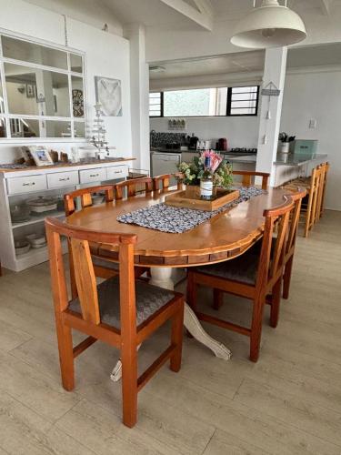 a kitchen with a wooden dining room table and chairs at Baby Whale Bliss - Beachfront House in Witsand