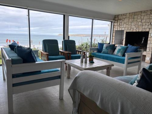a living room with couches and a view of the ocean at Baby Whale Bliss - Beachfront House in Witsand