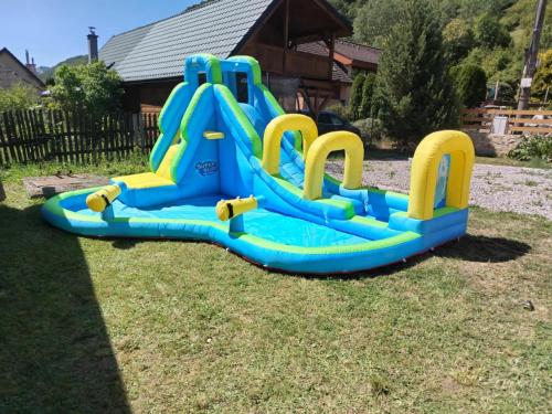 a blue and yellow water slide in the grass at Chata Myto pod Ďumbierom in Mýto pod Ďumbierom