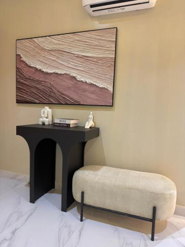 a room with a table and a bench and a painting at Luxury Home in Araromi