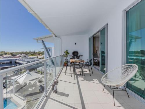 a balcony with chairs and a table on a building at The Top Deck Retreat Ballina in Ballina