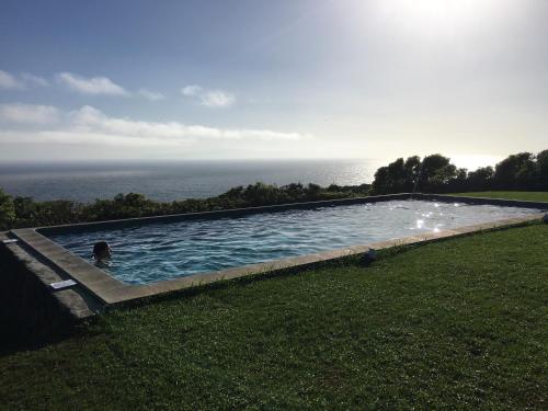 a person in a swimming pool with the ocean in the background at Pico da Vigia in Santa Bárbara