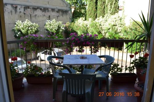 a table and chairs on a balcony with flowers at Albergo Cinzia in Florence