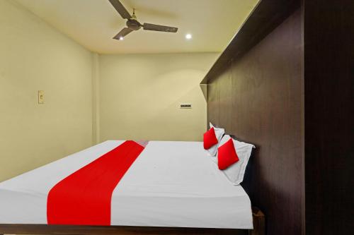 a bedroom with a bed with red pillows on it at Hotel O Le Serenity Beach View Resort in Kottakupam