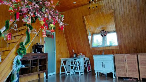 a kitchen with a table and a chandelier in a room at WindHill Homestay Bảo Lộc - Căn Villas Nhà Gỗ in Bon Tan Djiran B