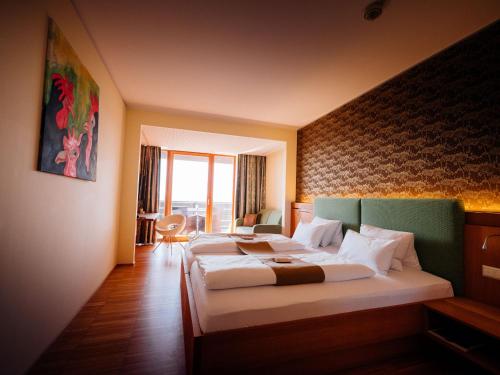 a hotel room with two beds and a large window at Genusshotel Riegersburg in Riegersburg