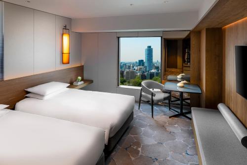 a hotel room with two beds and a desk at Hyatt Regency Tokyo in Tokyo