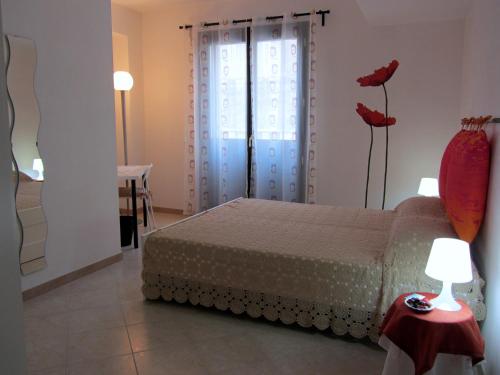ein Schlafzimmer mit einem Bett und einem Tisch mit einer Lampe in der Unterkunft Casa Corallo in Ispica