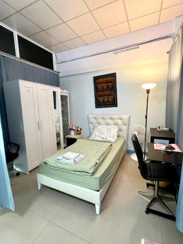 a bedroom with a bed and a desk and a chair at FirstFloorDormA in Ban Nong Khwang Tawan
