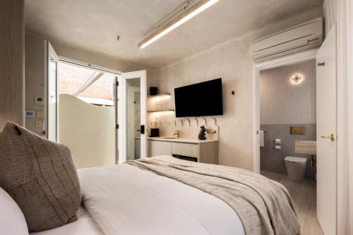 a bedroom with a bed and a television and a bathroom at Medusa Hotel Sydney in Sydney