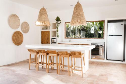 cocina con encimera blanca y taburetes de madera en Canggu Family Villa Pool Fence Available, en Canggu