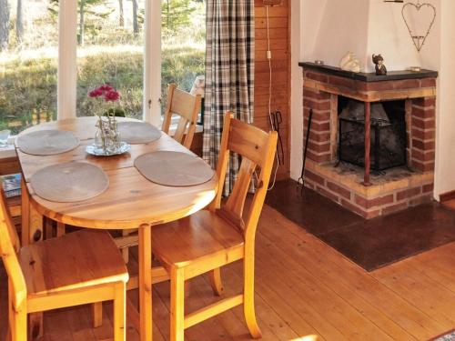 a wooden table and chairs in a room with a fireplace at 4 person holiday home in Ulfborg-By Traum in Fengersfors