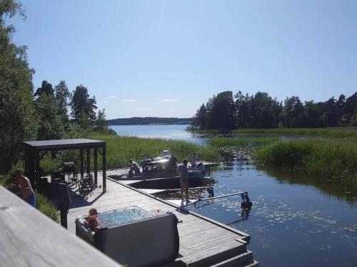 people in a hot tub on a dock on a lake at 4 person holiday home in Ulfborg-By Traum in Fengersfors