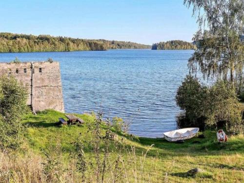 a boat sitting on the grass next to a body of water at 4 person holiday home in Ulfborg-By Traum in Fengersfors