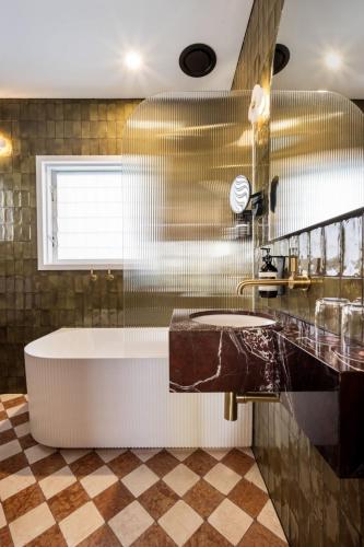 a bathroom with a tub and a sink at Medusa Hotel Sydney in Sydney