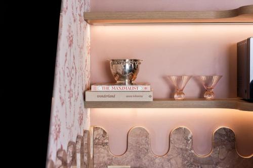 a shelf with a trophy and two glasses on it at Medusa Hotel Sydney in Sydney