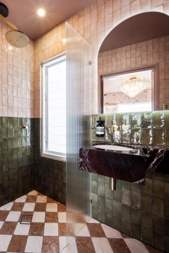 a bathroom with a shower with a sink and a window at Medusa Hotel Sydney in Sydney