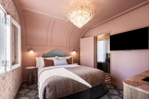 a bedroom with a large bed and a chandelier at Medusa Hotel Sydney in Sydney