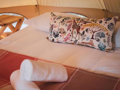 a bed with a pillow and a towel at The Leadwood Safari Camp in Dinokeng Game Reserve