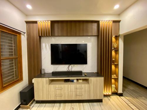 a living room with a flat screen tv on a wall at Sakya Stays - Service Apartment in Kākināda