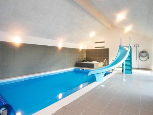 a swimming pool with a blue slide in a building at 22 person holiday home in Jerup in Jerup