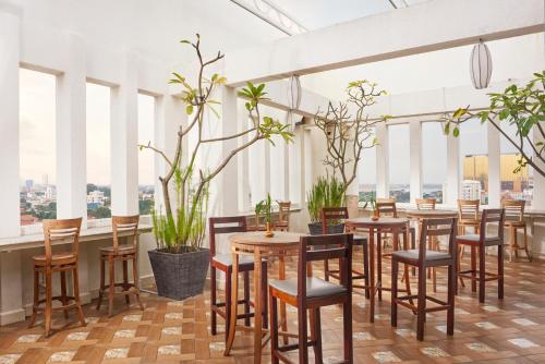 a row of tables and chairs in a room with windows at Phnom Penh Katari Hotel in Phnom Penh