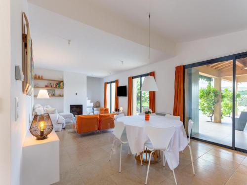 a dining room and living room with a white table and chairs at Villa in Malaucène with Mont Ventoux Views in Malaucène