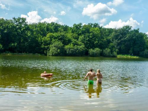 a couple of people swimming in a lake at Castle in Le Veurdre near Forest and River in Le Veurdre
