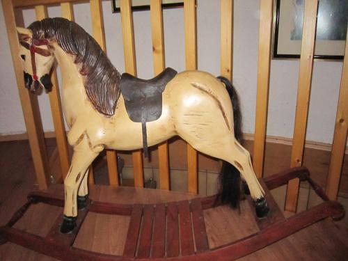 a toy horse sitting on a rocking chair at Strotzbüsch Forest Hideaway in Strotzbüsch
