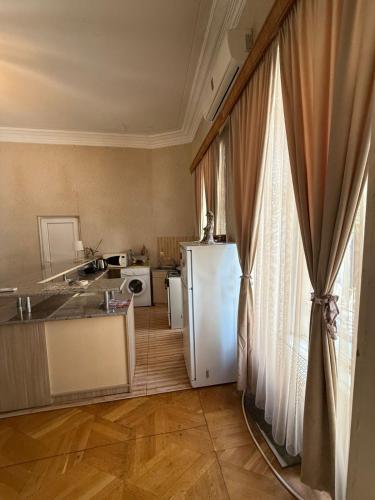 kuchnia z lodówką, stołem i oknem w obiekcie Apartment Mate w mieście Tbilisi City