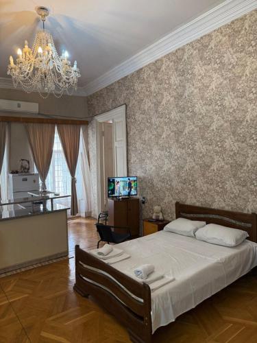 sypialnia z dużym łóżkiem i żyrandolem w obiekcie Apartment Mate w mieście Tbilisi City