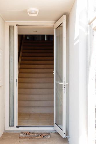 a glass door leading up to a staircase at Sandy Nook Beachfront Bliss with uninterrupted Ocean Views in Port Fairy