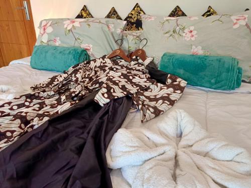 a bed with a dress and pillows on it at Skylodge B&B - Bali Jungle Retreat with Fine Dining & Eco Pool in Bukti